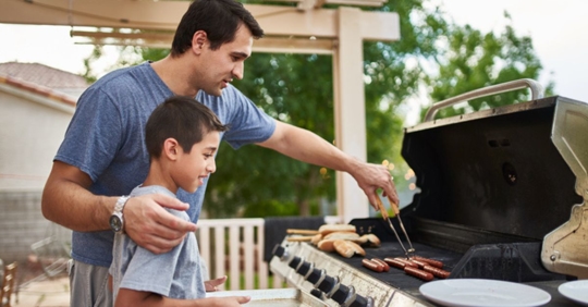 man grilling with son