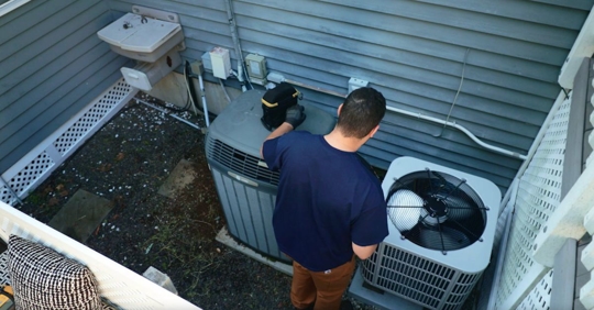 HVAC technician working on AC unit.